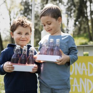smiley little kids with lemonade front view
